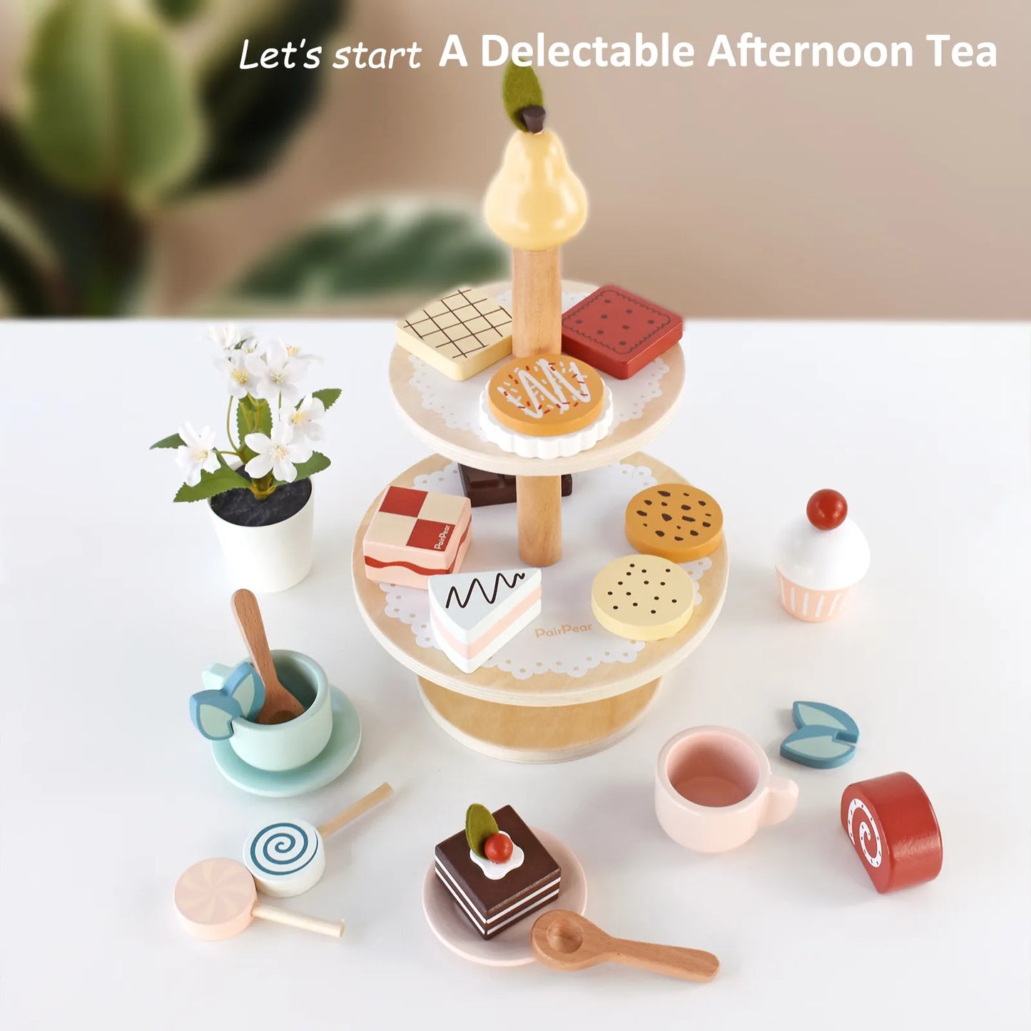 Wooden afternoon tea toy set for kids with a two-tier dessert stand, teacups, and colorful pretend play food cakes displayed on a white table
