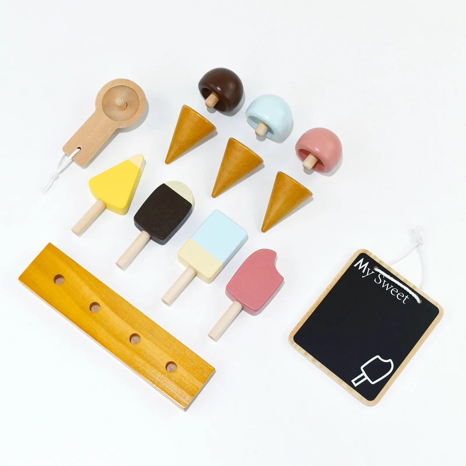 Flat lay of all wooden ice cream toy accessories. This pretend play food set includes colorful popsicles, stackable cones, scoops, and a chalkboard.