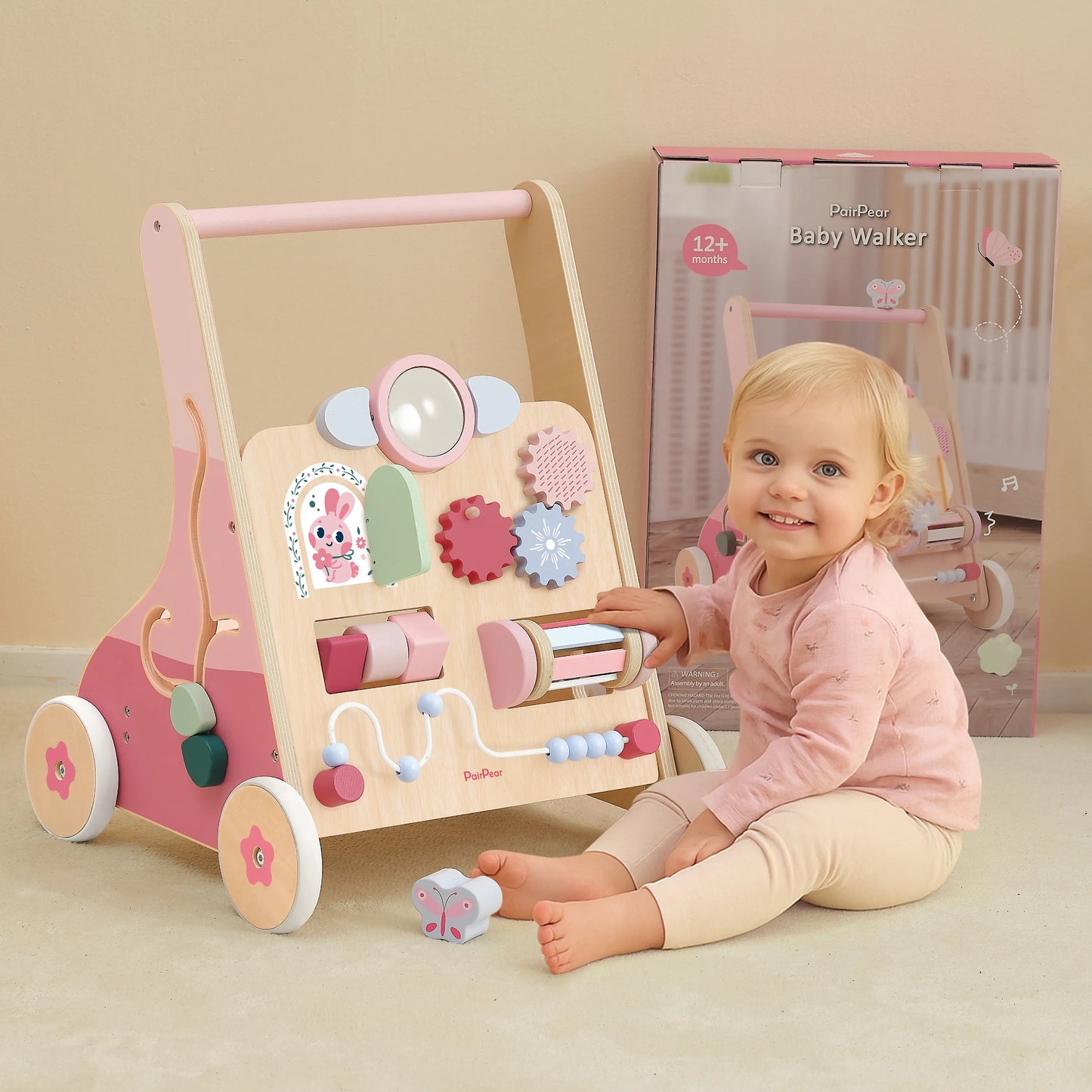 Smiling baby girl playing with the pink wooden activity center walker. Includes original packaging, making it a perfect gift for toddlers 12+ months.