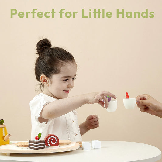 Toddler holding a wooden teacup during an imaginary tea party. This kids play food set is the perfect size for little hands to build motor skills